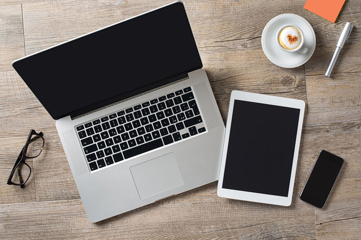 mac laptop, iPad, and iPhone on wood desk